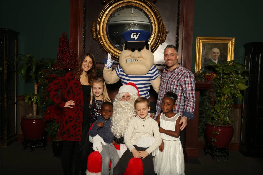 Family of six posing with Santa and Louie